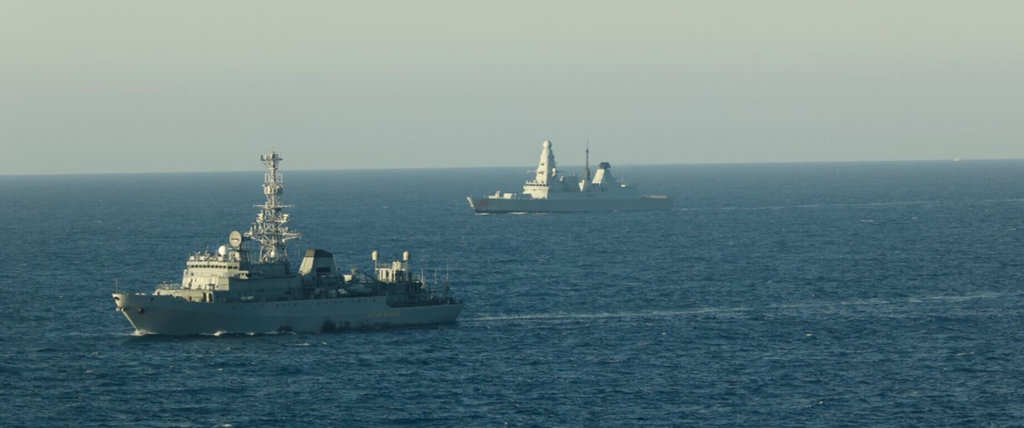 英國海軍29日指出，俄羅斯間諜船「尤里伊凡諾夫號」（左）5月中旬現蹤英國水域，英方出動防空驅逐艦「龍」（右）及「梅林」反潛直升機伴隨監控。 圖：英國海軍提供