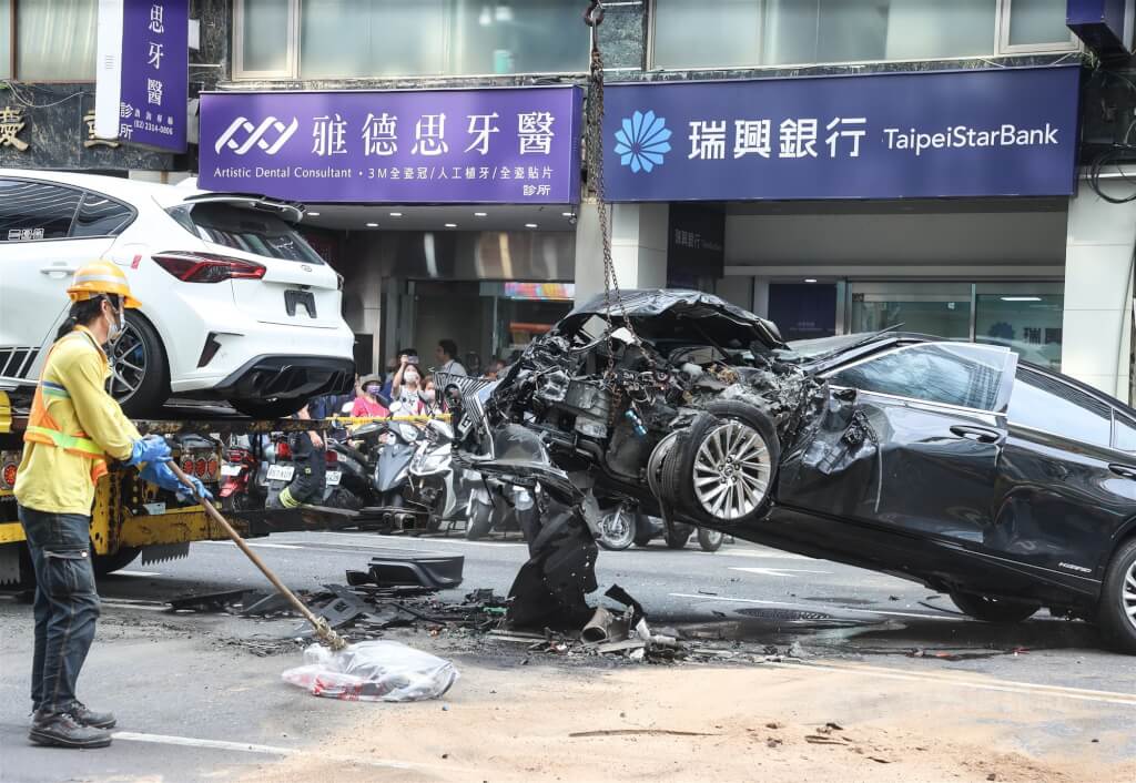 台北市重慶南路23日發生嚴重車禍，一輛黑色自小客車（右）不明原因突然失控暴衝，與3輛汽車及1輛公車發生碰撞，黑色自小客車頭近全毀。中央社記者謝佳璋攝  114年5月23日