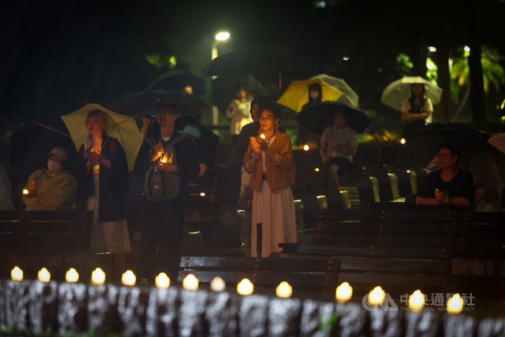 「在台港人六四燭光晚會」4日晚間在台北228和平公園舉行，儘管天氣不佳、飄著雨絲，仍有許多人到場持小燭光響應參與，悼念六四。 圖：中央社