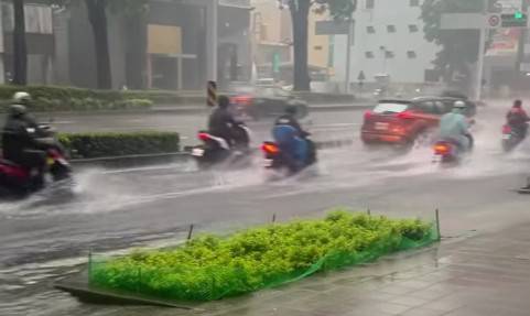 高雄市上班時間慢車道積水，車輛涉水而過。 圖：孫家銘翻攝