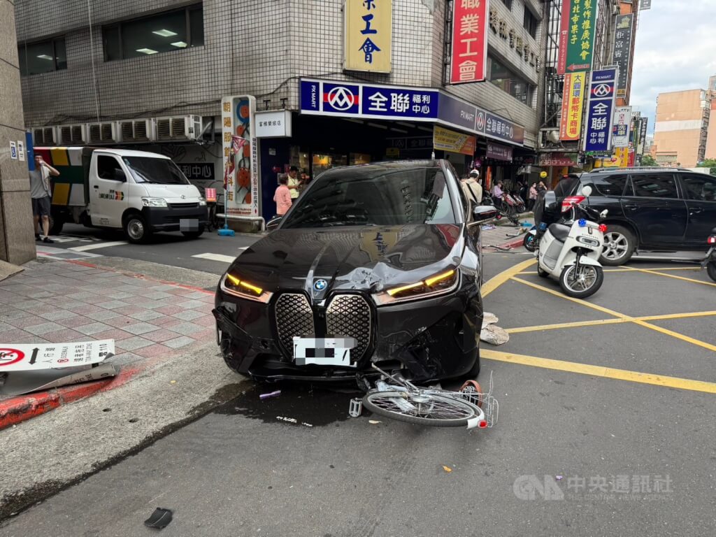 台北市警消20日下午獲報在南京西路167巷附近發生車禍，人員到場發現一輛黑色BMW汽車卡在路口，附近多輛機車及自行車受損，另有1名年約60幾歲婦人受傷，涉肇事駕駛為74歲曾姓男子。（翻攝照片）中央社記者劉建邦傳真  114年6月20日