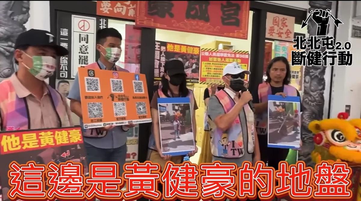 婦人突襲搶奪罷團旗桿攻擊志工，還嗆「這邊是黃健豪的地盤」，「斷健行動2.0」表示，婦人看手機後，「彷彿接受到指令」攻擊，做筆錄時黃健豪的人員在第一時間到場，質疑是否和施暴婦人有聯繫？ 圖：截自「斷健行動-罷免黃健豪 2.0」臉書影片