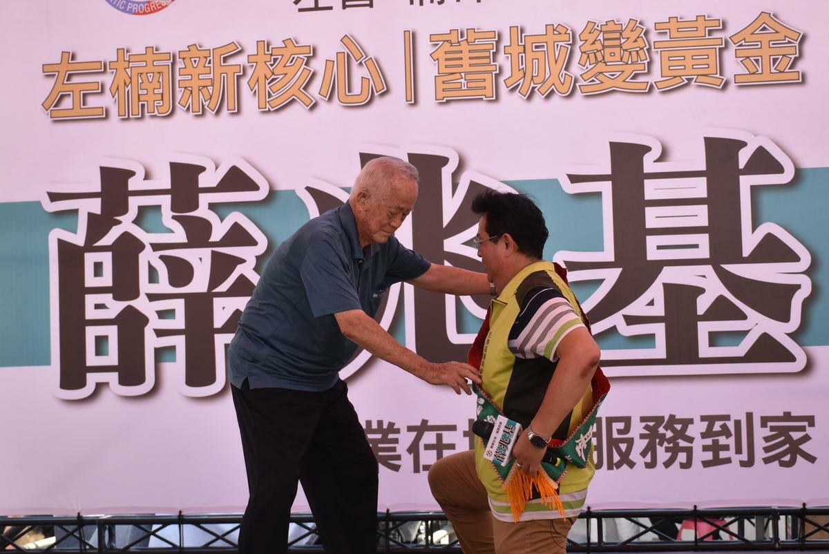 薛兆基(右)由父親親手披上綠色的參選人彩帶。 圖：孫家銘攝