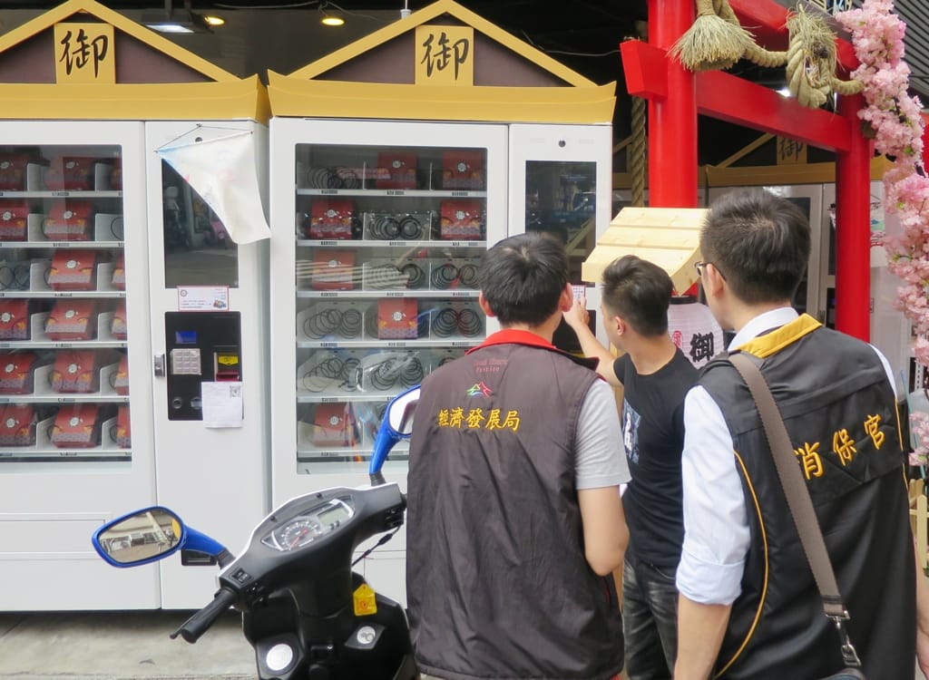 台中市政府消保官與經發局前往台中一中商圈進行稽查，發現市面上近三十台的百元販賣機皆未辦理營業登記，而且聯絡資訊僅有電話、臉書或是Line，沒有業者名稱或地址。 圖 : 台中市政府法制局 / 提供