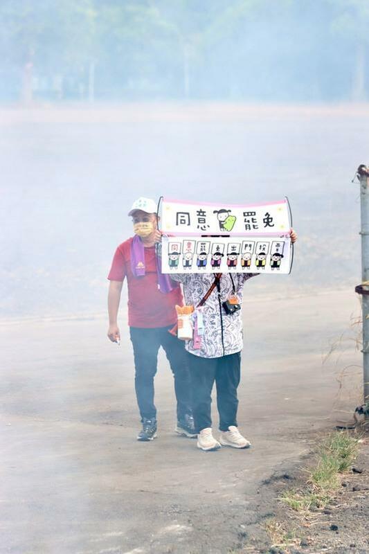 王義川領軍破千台機車掃街挺罷免，民眾在路旁舉起挺罷免橫幅。 圖：王義川辦公室/提供