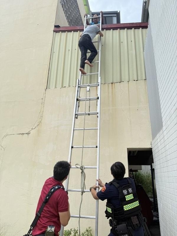 台南一名婦人防颱檢查跌落鐵皮屋頂，警消架梯協助婦人脫困。 圖/台南市政府警察局第四分局提供