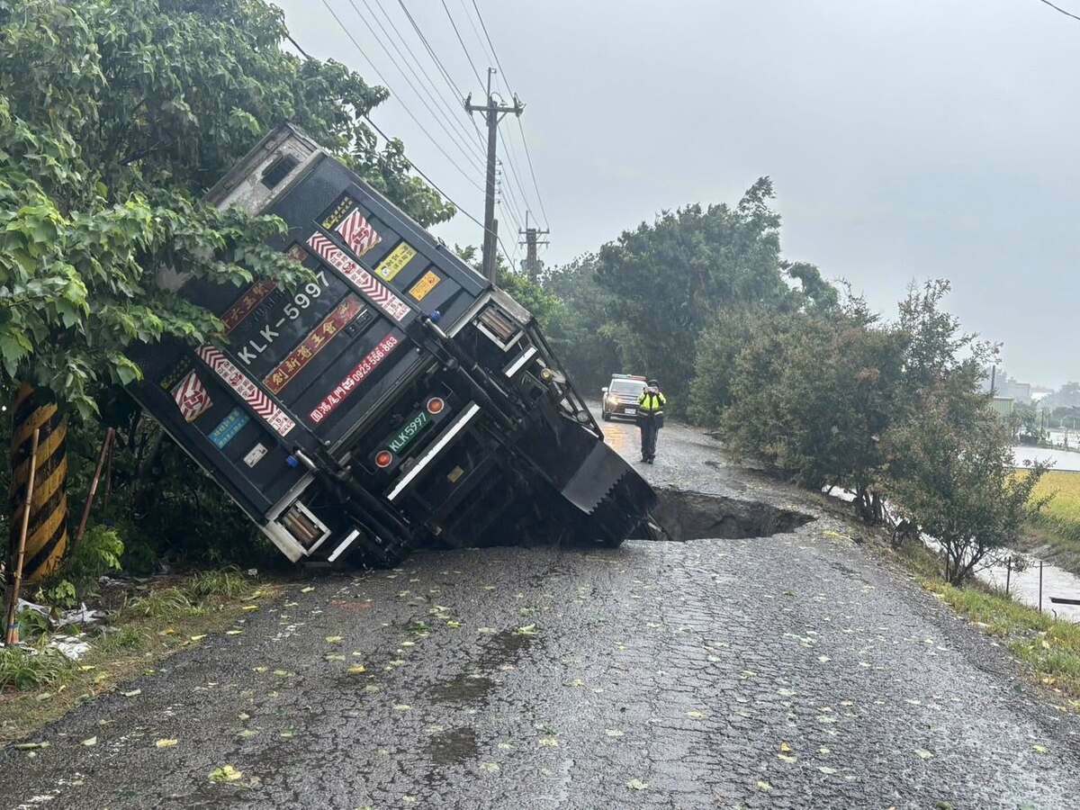 彰化縣二林鎮受強降雨影響，地面出現天坑，大貨車受困動彈不得。 圖：取自彰化縣媒體記者協會