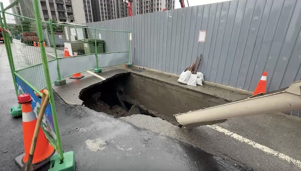 苗栗縣頭份市一處建築工地旁道路9日驚現「天坑」，引發居民恐慌。縣府工商發展處獲報派員勘查、要求廠商灌漿回填，並勒令建案立即停工，持續調查原因與責任。（民眾提供）中央社記者管瑞平傳真  114年7月9日