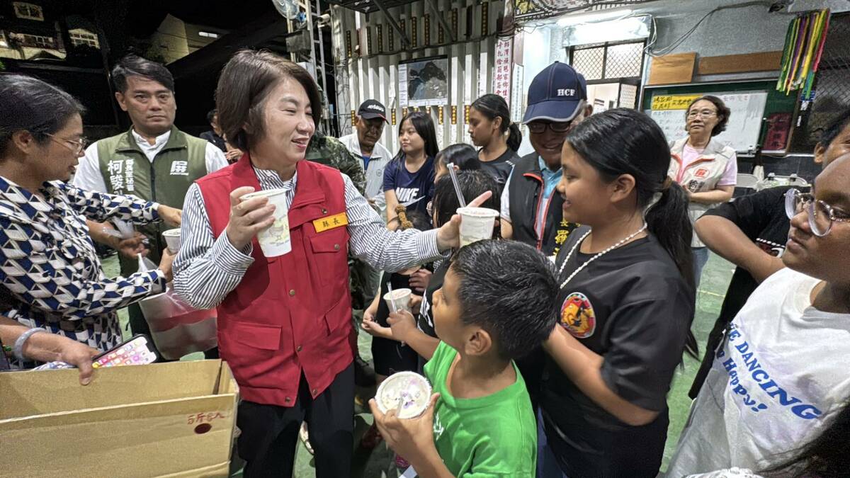 周春米(左三)在收容中心發送飲料給撤離民眾。 圖：屏東縣政府/提供