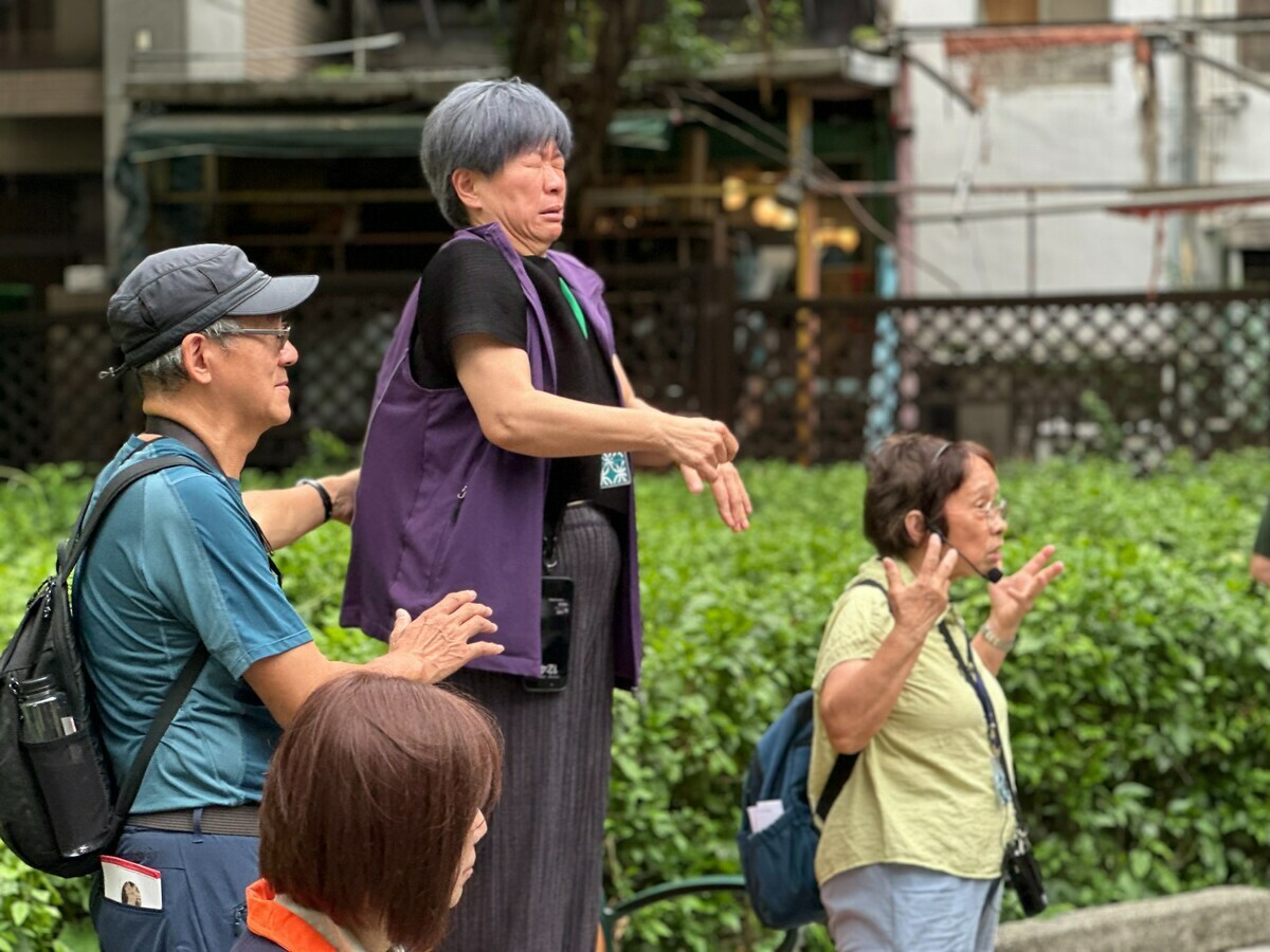 參觀東本願寺不義遺址時，受難者家屬涂貴美（右）講述當年受難者遭受不當偵訊，手譯員同步手語演示驚恐表情。 圖：國家人權博物館提供