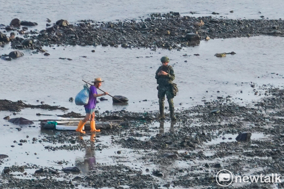 火炮實彈射擊前，一位福正村民仍在福正海域收網，一位阿兵哥趕忙衝到沙灘，要求老人盡快離開預訂射擊的海域。 圖：張良一/攝