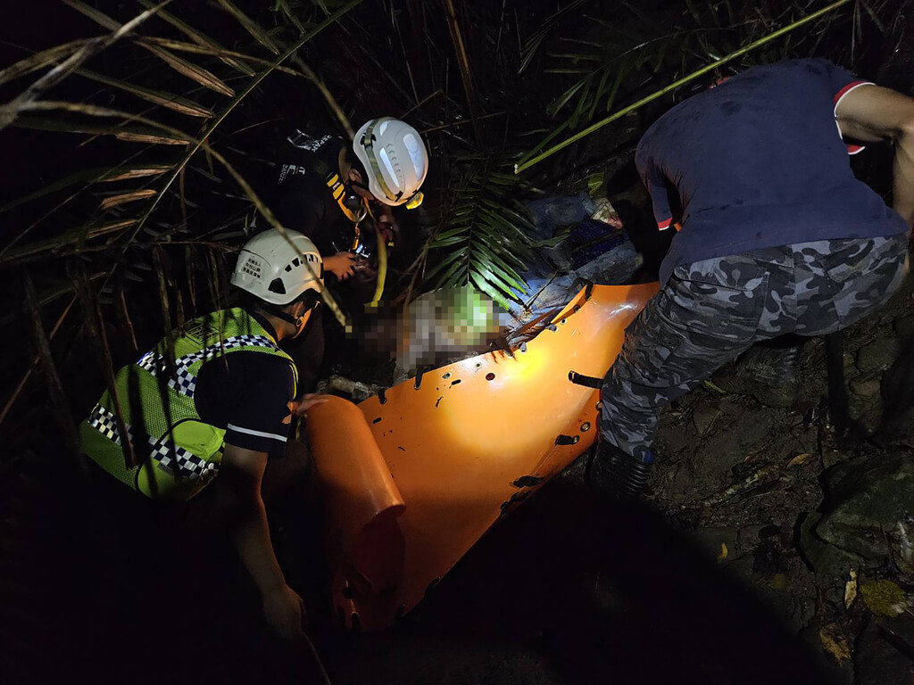 南投縣國姓鄉竹坑巷16日晚間有自小客車墜谷約20公尺深，車上1人受傷自行脫困，另1人拋飛至車外，消防人員架繩索下降救援時發現已明顯死亡，利用繩索、吊臂、捲式擔架將其拖至地面，交由員警處理。（南投縣消防局提供）中央社記者鄭維真傳真  114年7月17日