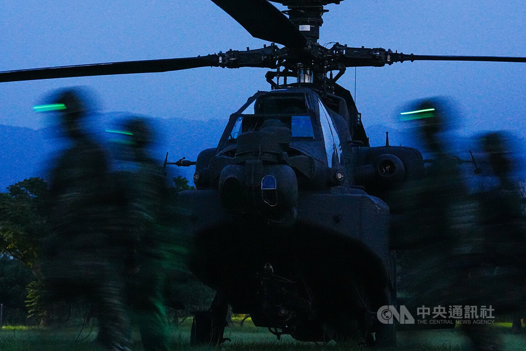AH-64E阿帕契攻擊直升機17日晚間實施夜間熱加油及掛彈訓練，圖為官兵配戴綠色頭燈列隊經過阿帕契機頭。中央社記者游凱翔攝  114年7月17日 圖：中央社提供