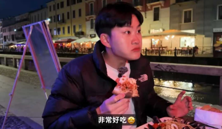 Joeman在運河旁的餐廳吃晚餐時，突轉頭對鏡頭外的人說了句「非常好吃」，舉動不太自然。 圖：翻攝自Joeman YT頻道