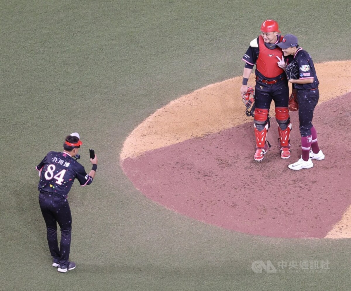 中職明星賽20日迎來第2戰，6局下，TEAM STAR守位大搬風，外野手郭天信（右）登板投球、內野手劉基鴻（右2）蹲捕，兩人在場中合影留念。中央社記者張新偉攝　114年7月20日