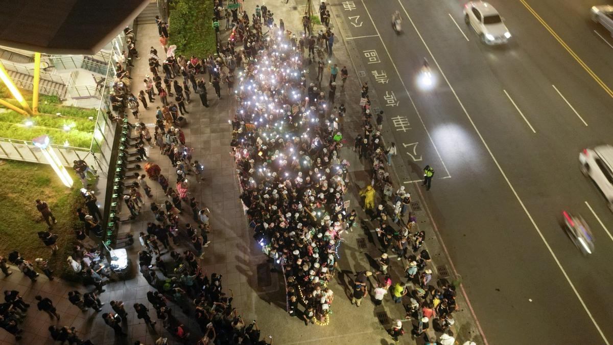 志工與市民以手機燈光排列出「點亮台灣」畫面，象徵人民以和平、溫柔但堅定的方式，照亮台灣的未來。 圖：Wecare高雄/提供