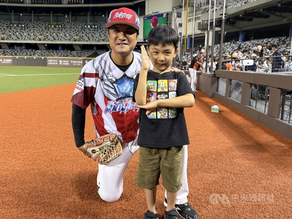 中華職棒統一7-ELEVEn獅隊「超人力霸王」主題日登場，25日安排打擊教練潘武雄（左）5歲小兒子潘緯宸（前右）開球，拍合照時，潘緯宸馬上比出「超人力霸王」招牌手勢。中央社記者謝靜雯攝　114年7月25日