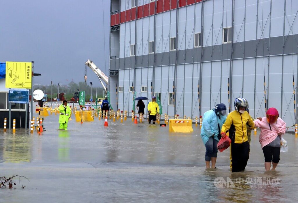 受低壓帶與西南風影響，嘉義縣28日清晨起降豪大雨，位於嘉義科學園區興建中的台積電先進封裝廠工地淹水，員工涉水通行。 圖：中央社