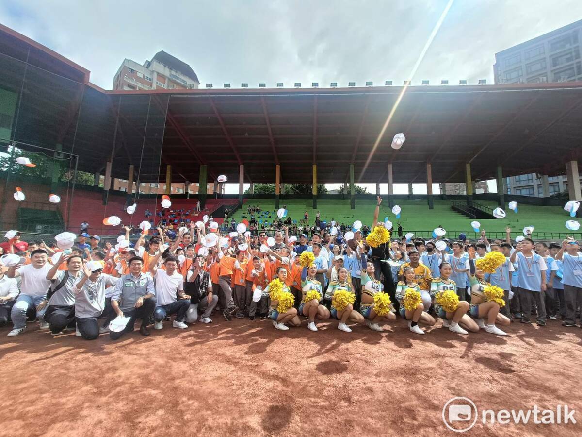 參加棒球營小朋友歡欣鼓舞丟帽慶祝開幕。 圖：唐復年攝