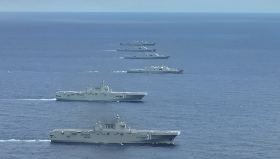 新華網報導，075型兩棲攻擊艦海南號（鏡頭前第1艘）、湖北號（第2艘）與至少4艘護衛艦在南海某海域進行實戰化訓練。 圖：翻攝新華網