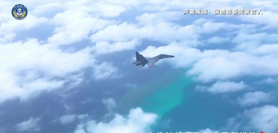中國解放軍南部戰區出動歼-16 多用途戰機，進行實彈戰備巡邏。背景為南海珊瑚礁與海域，可見高度清晰的海底輪廓，顯示飛行高度不高，具威懾意味。 圖：翻攝自藍星筆記