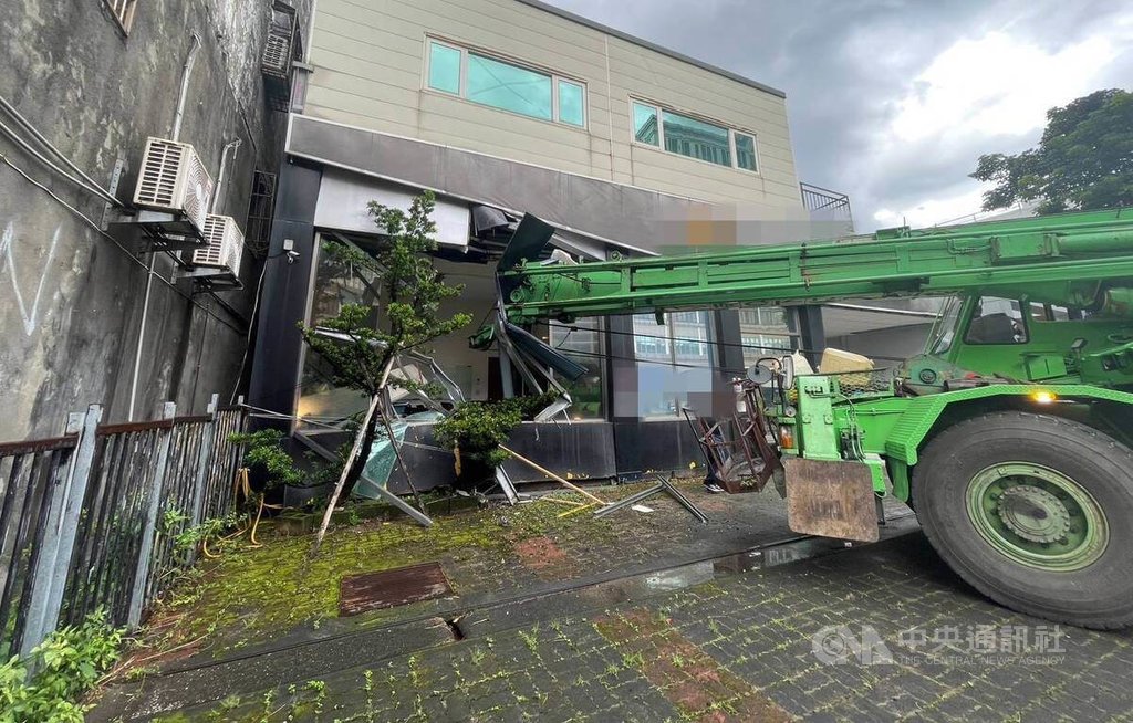 1輛大型吊車2日行經台北市南港路三段一帶時，疑因煞車失靈先是衝撞路燈後又撞毀民宅1樓窗戶，最終卡在人行道上，駕駛酒測值為零，詳細肇事原因仍待查。（翻攝畫面）中央社記者劉建邦傳真  114年8月2日