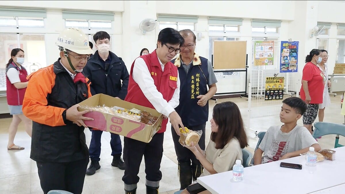 陳其邁(左三)親自發放麵包給安置民眾。 圖：高雄市政府/提供