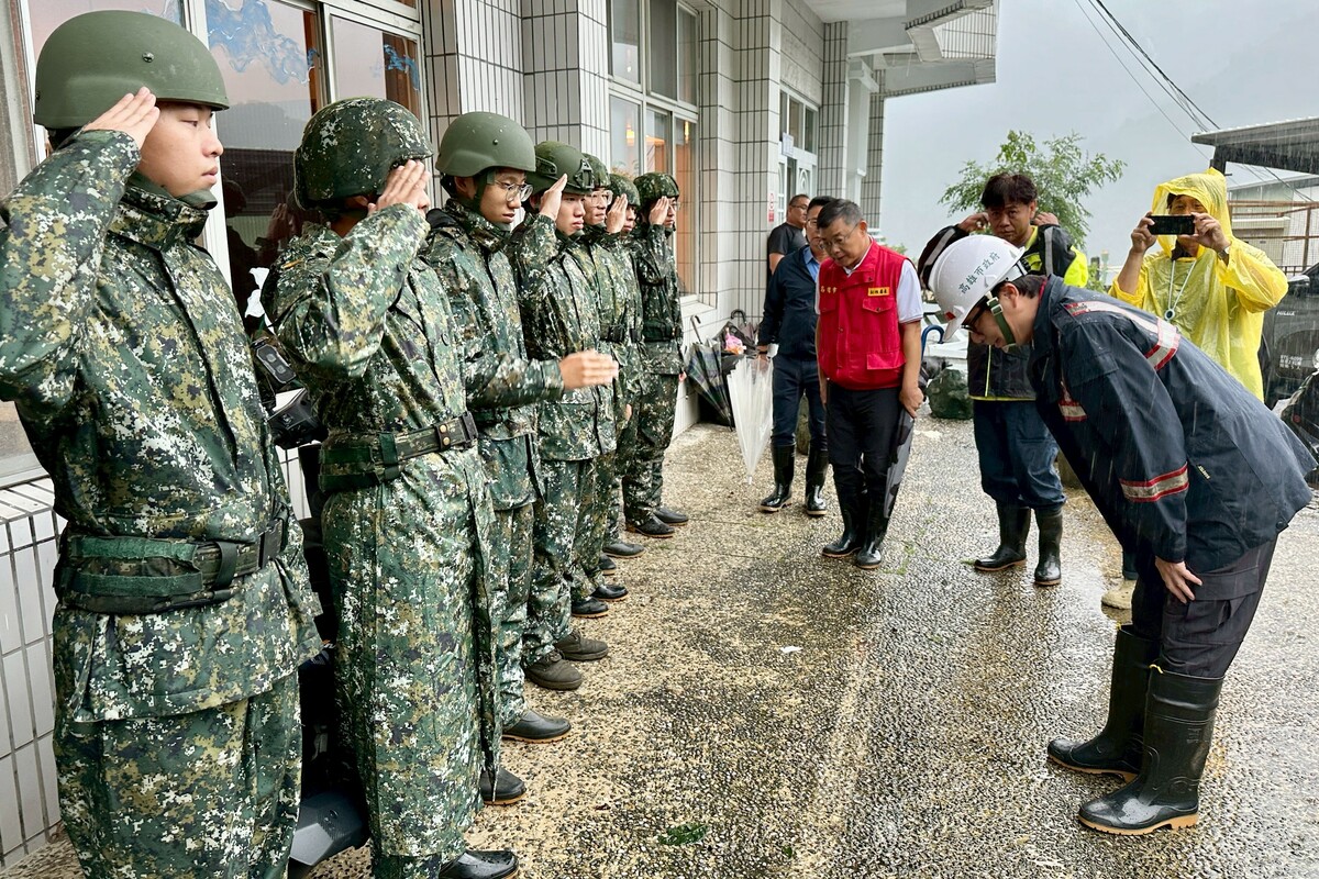 其邁(右一)向辛苦救災的阿兵哥鞠躬致謝。 圖：高雄市政府/提供