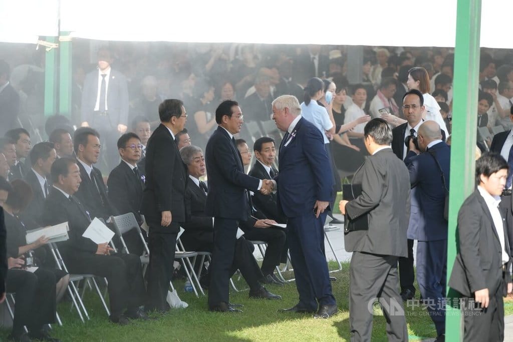 2025年8月6日是「原爆日」80週年紀念日。美國駐日大使葛拉斯（中，白髮者）出席，和日本前首相岸田文雄（站立者左2）握手寒暄。. 圖：中央社提供