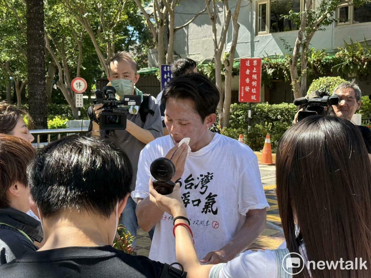 民眾黨主席黃國昌車掃前擦防曬乳，不小心擦太多變「小白臉」，趕快照鏡子把多餘的防曬乳擦掉。 圖：周煊惠 / 攝