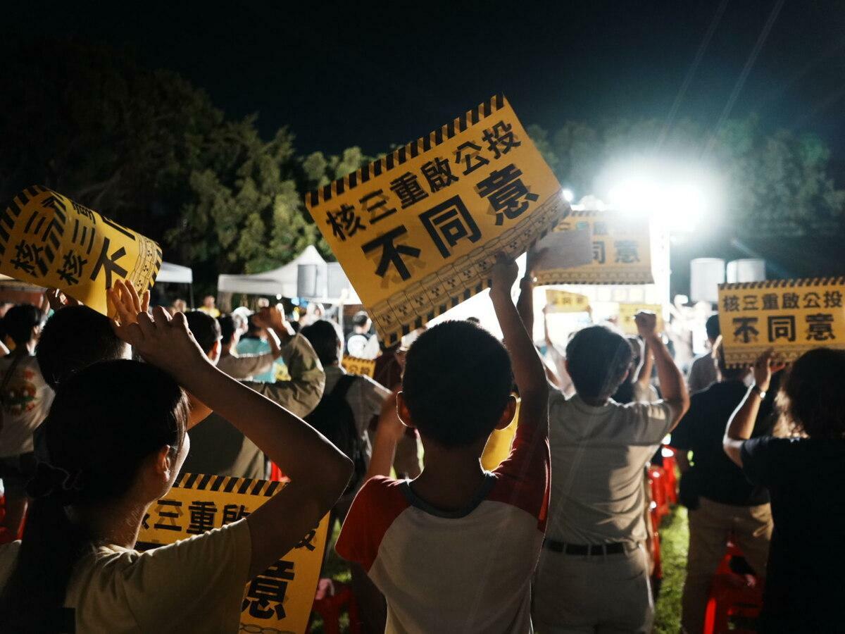 屏東民眾在台下高舉「核三重啟公投不同意」標語。 圖：地球公民基金會提供/郝渂心攝