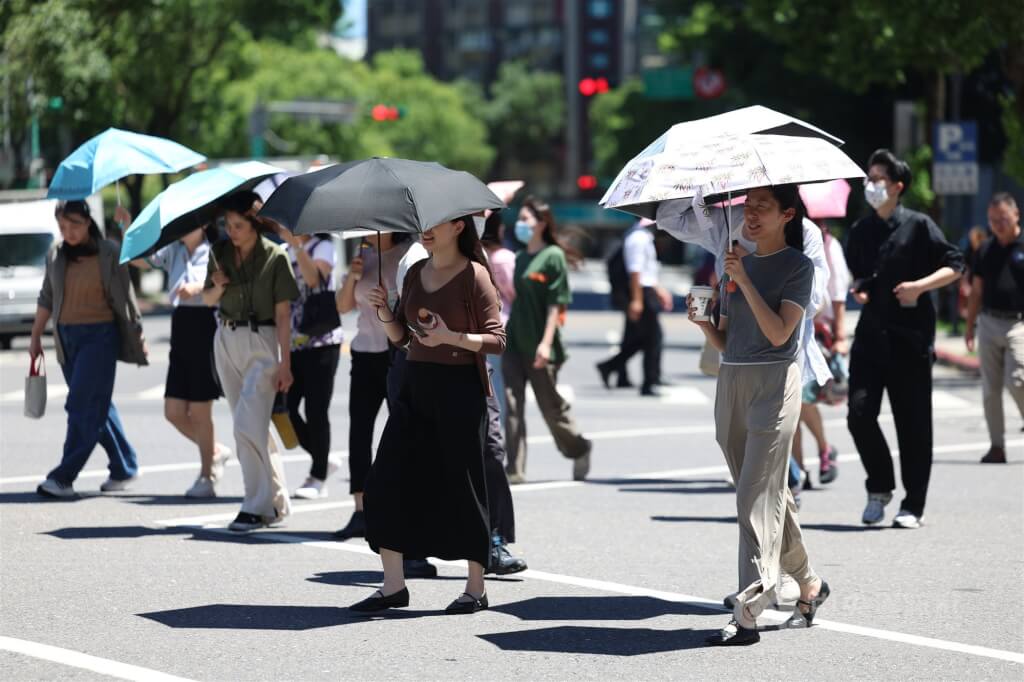 圖為台北市信義區民眾撐傘防曬。 圖：中央社檔案照片