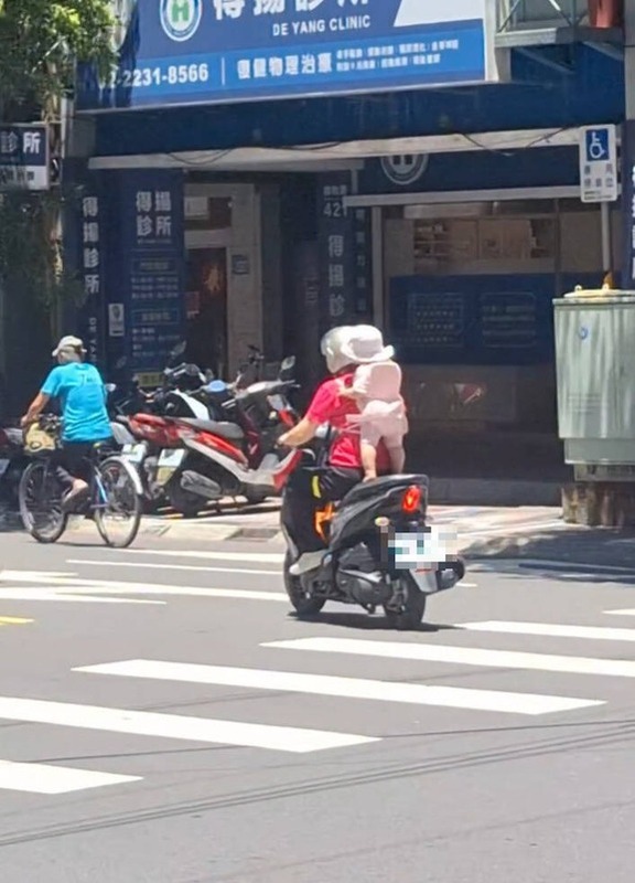 永和街頭有婦人機車後座僅繩綁幼童站立，驚險畫面上傳Threads 引網友怒批拿孩子性命開玩笑。 圖：翻攝自Threads @_7uzon