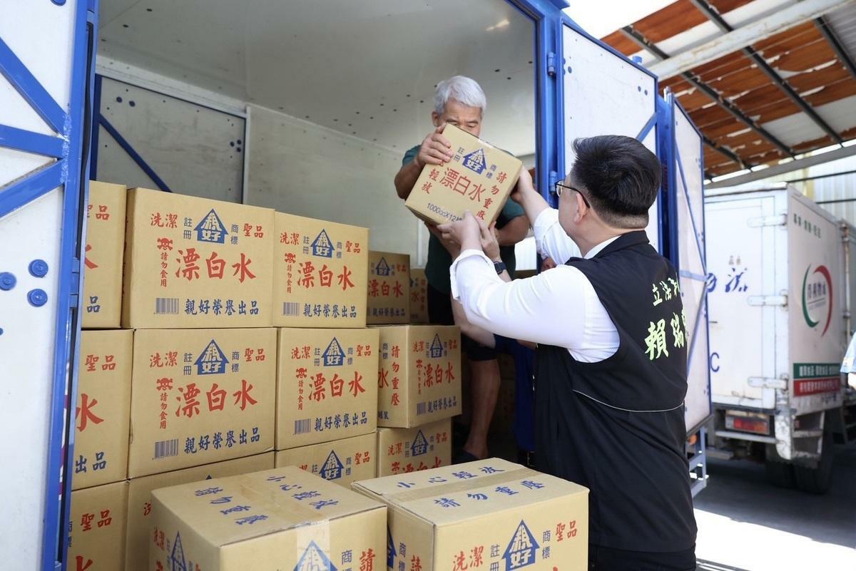 賴瑞隆(右)親手將漂白水搬上貨車運往台南新營。 圖：賴瑞隆辦公室/提供