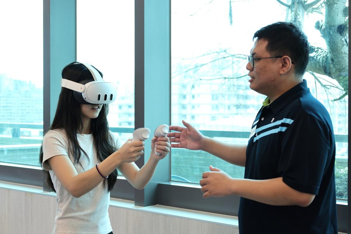 職安系鄭喻齊老師（右）引導學生體驗VR防墜設備。 圖：中山醫大/提供