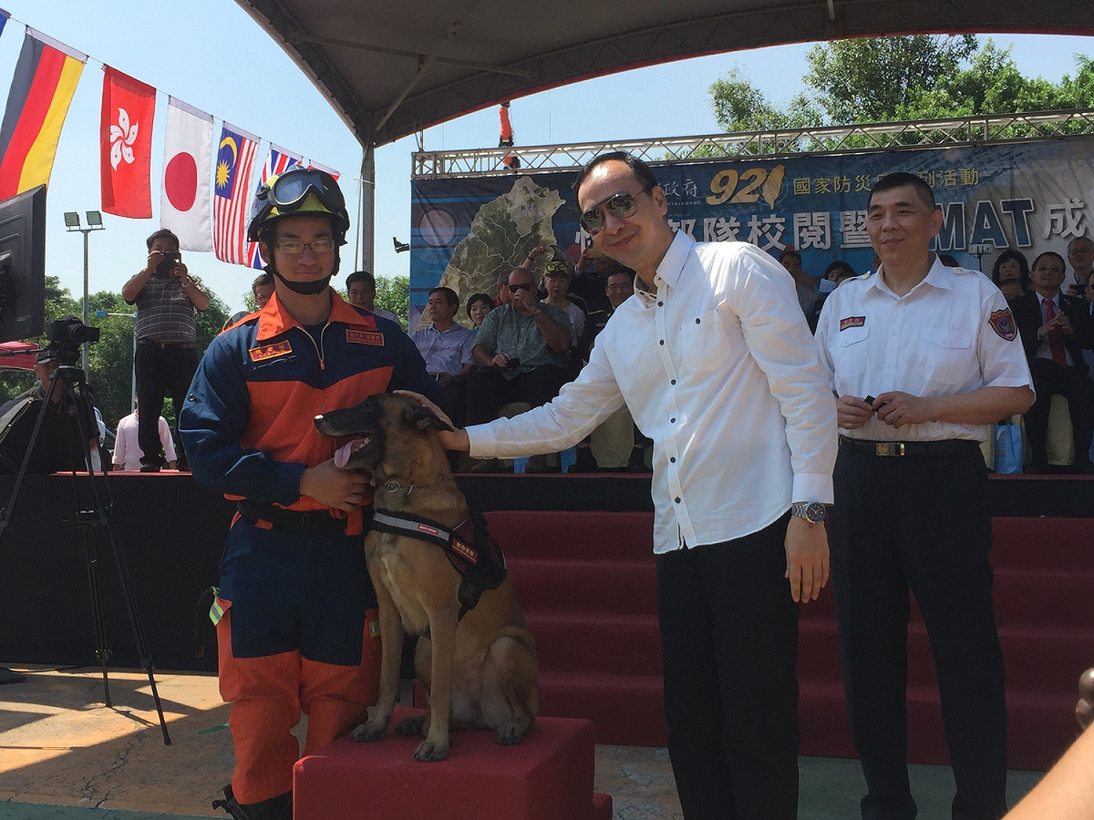 除了演練，今日還進行消防局4隻搜救犬(伊莎、奇諾、貝塔、貝兒)的授階，朱立倫還微笑拍拍搜救犬的頭表示勉勵。 圖：李書璇/攝