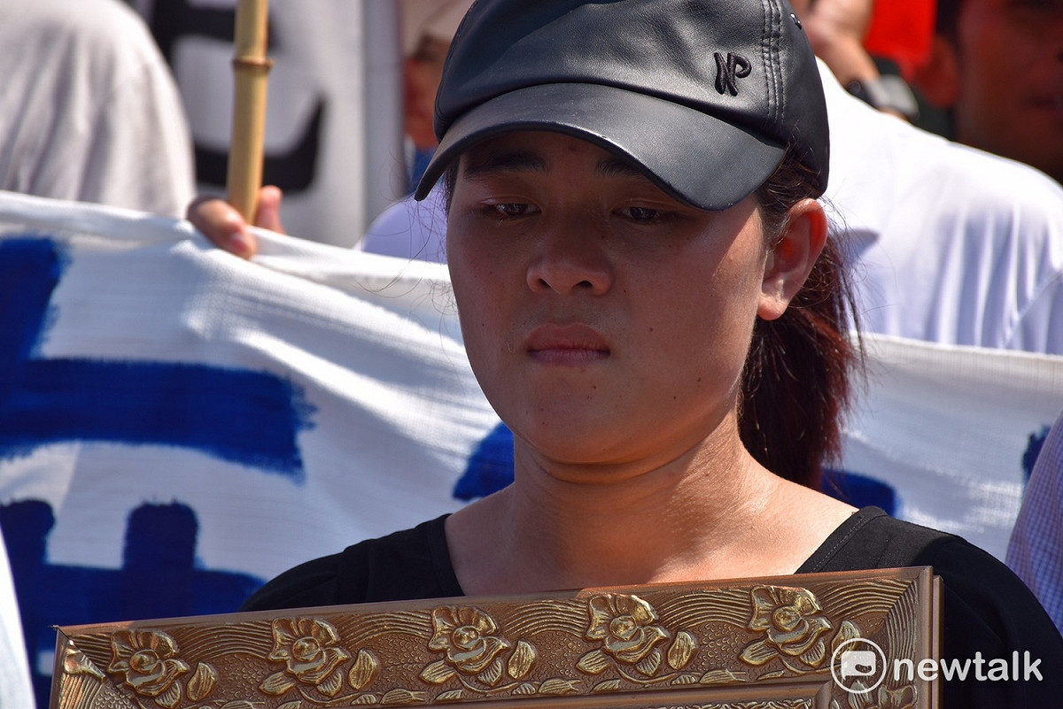 阮國非妹妹前往總統府陳情，雙手捧著哥哥阮國非的遺照。 圖：黃韋銓/攝