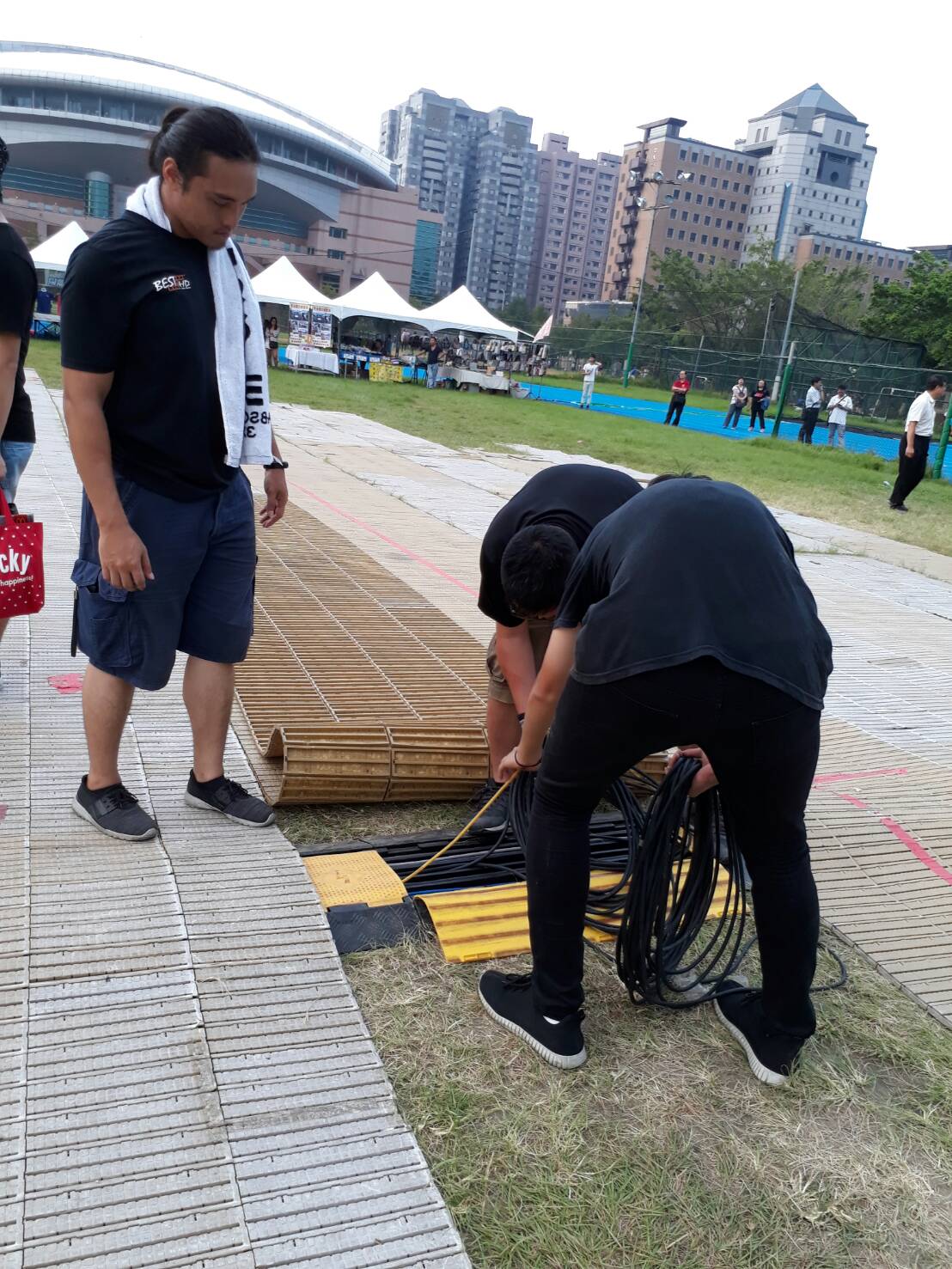 相關人員繼續檢視草皮，是否停止活動，引人質疑。 圖：陳香蘭/攝