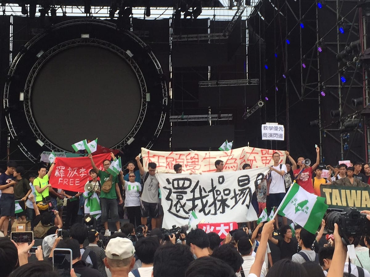 主辦單位一宣布活動終止後，學生立即衝上台高舉「還我操場」的旗幟，大聲呼口號慶祝抗議成功。 圖：丘秝榕／攝