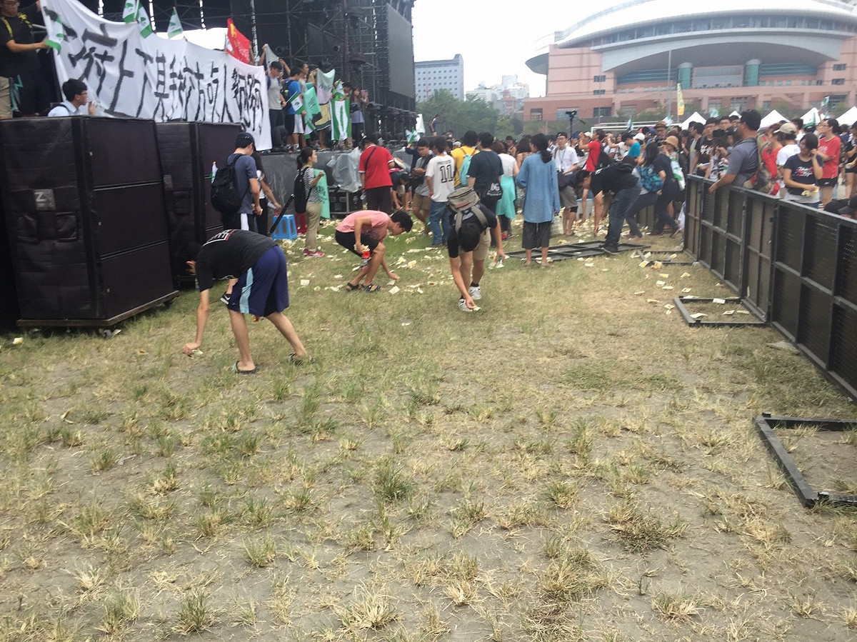 抗議學生向舞台撒冥紙抗議，在地板上留下許多垃圾，但事後抗議學生都自主性的清理場地，還給大家乾淨的台大校園。 圖：丘秝榕／攝