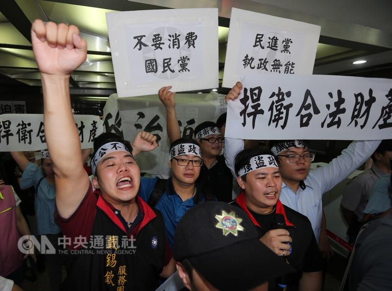 法務部行政執行署27日下午派員前往國民黨松山區黨部準備貼上正式封條，不少國民黨員在集結在黨部樓下，高舉布條、標語，高呼口號表達抗議。 圖 : 中央社