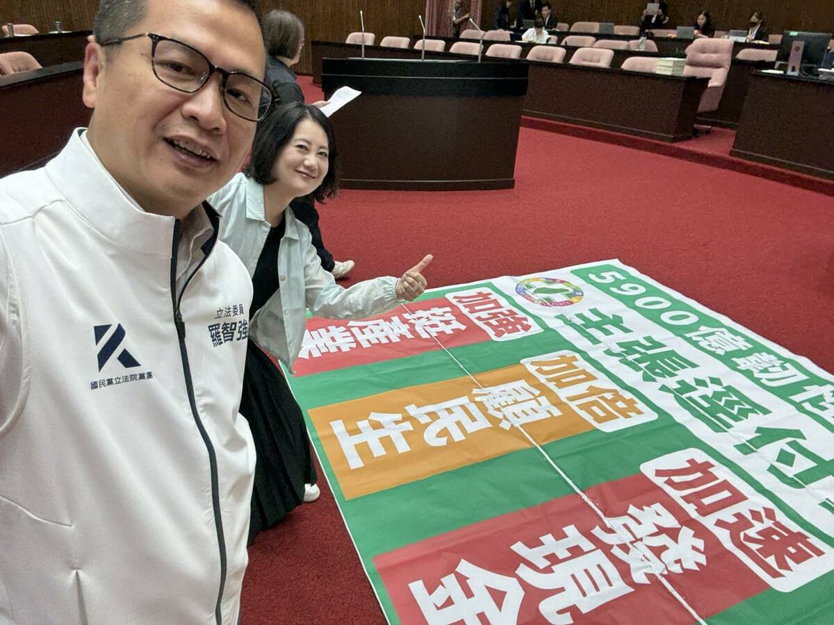 民進黨團幹事長吳思瑤找國民黨立委羅智強，一同在民進黨呼籲加速普發現金的布條前合照。 圖：擷取自羅智強臉書