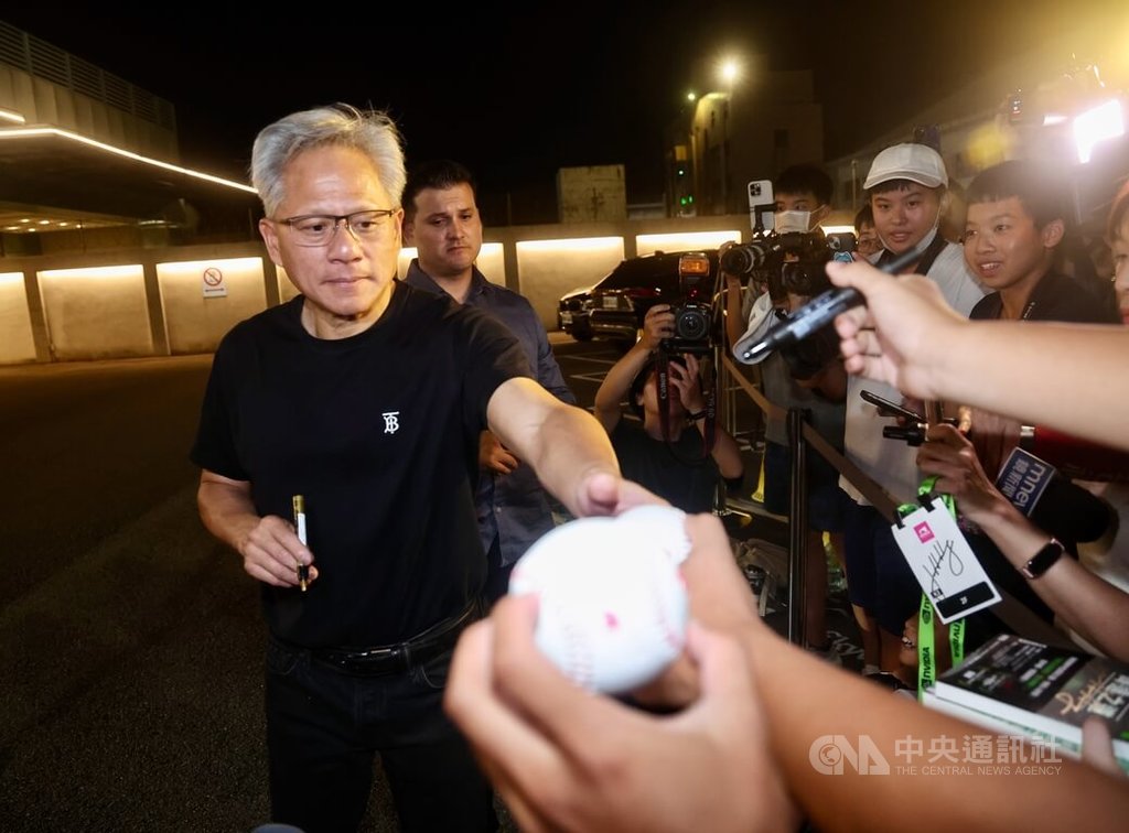 輝達（NVIDIA）執行長黃仁勳（左）22日搭乘專機快閃訪台，晚間搭機離台前，親切為前來送機的粉絲簽名留念。中央社記者張皓安攝  114年8月22日 圖：中央社提供