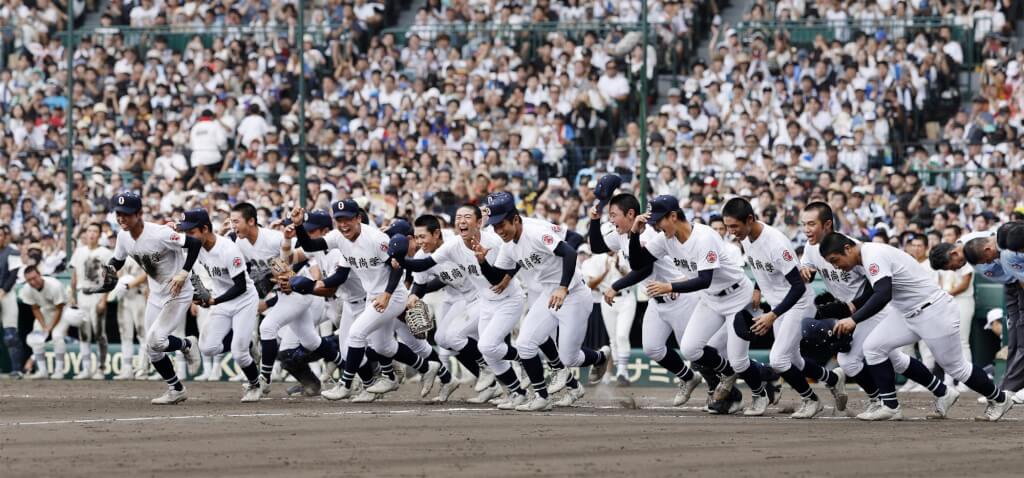沖繩尚學23日奪得校史首座夏季甲子園冠軍，球員興奮跑進場內慶祝。（共同社）