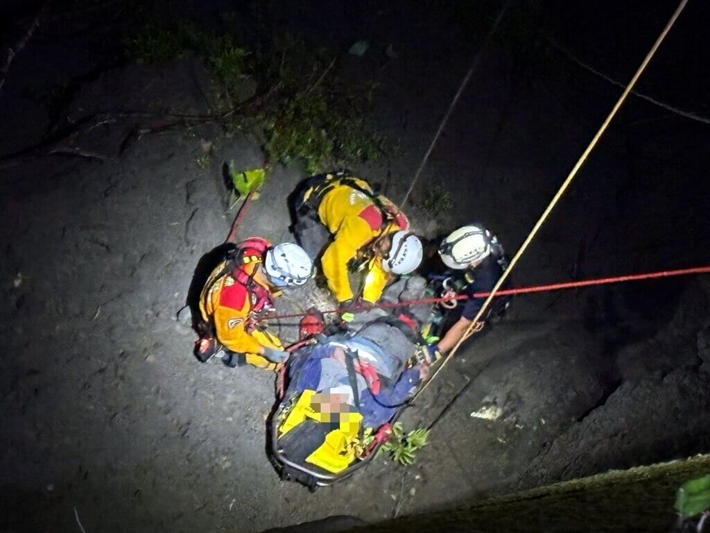 嘉義縣阿里山公路35.8公里處23日深夜發生大型重機車自撞墜谷意外，鄭姓騎士跌落邊坡約50公尺深谷，消防人員架設繩索協助脫困，鄭男被救起時，身體多處擦挫傷，無生命危險。（警方提供）中央社記者黃國芳傳真　114年8月24日