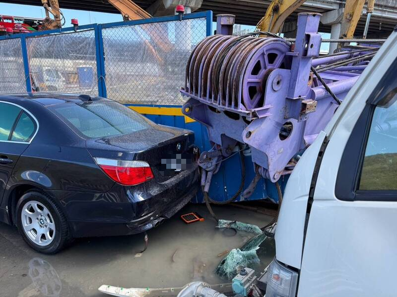 捷運環狀線北環段施工工地，一輛吊車在移動作業時，吊車突然因不明原因陷落翻覆，砸中一旁自小客車及工地水塔。 圖：警方提供