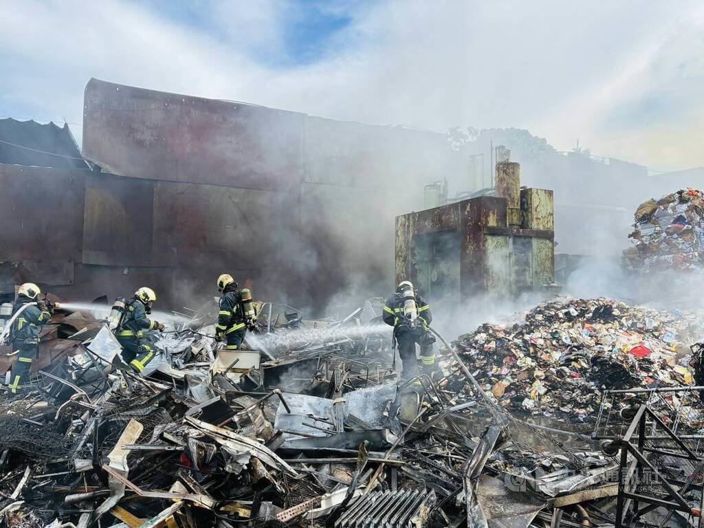 台北市松山區一間資源回收場26日發生火警，由於地點鄰近松山機場，火場濃煙直竄天際引關注，消防人員到場救援，經控制火勢後仍有殘火，直到下午4時才完全撲滅，幸無人傷亡。（翻攝照片）中央社記者黃麗芸傳真　114年8月26日