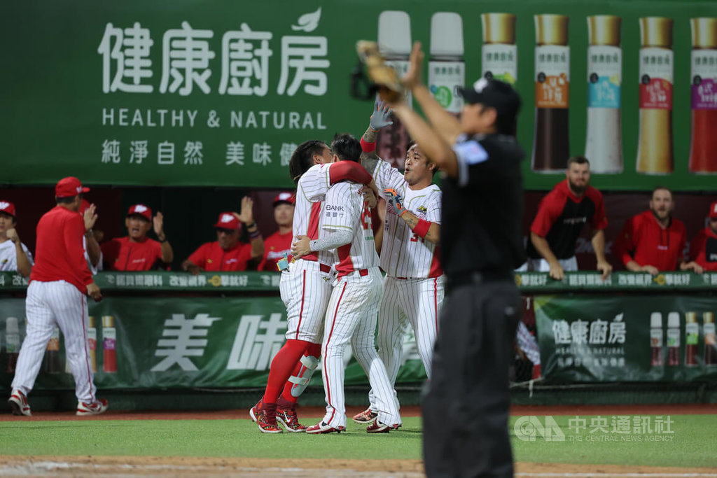中華職棒味全龍隊26日與統一獅隊鏖戰至延長賽，10局下半龍隊靠著曾聖安再見安打以2比1搶勝，場邊球員開心擁抱互相致意慶祝。中央社記者翁睿坤攝  114年8月26日