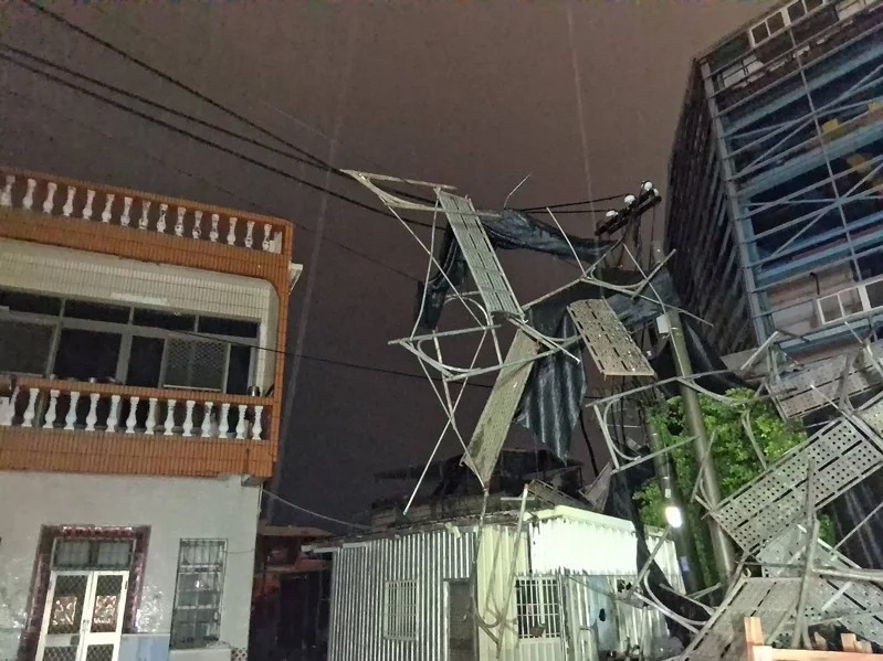 高雄昨日突降暴雨導致鷹架倒塌，壓斷供電線路使旗津大停電。 圖：民眾提供