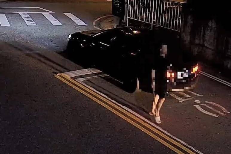 男子因不滿遭後方車輛閃大燈，把車臨停在路中央並手持木棍攔車理論。 圖：警方提供